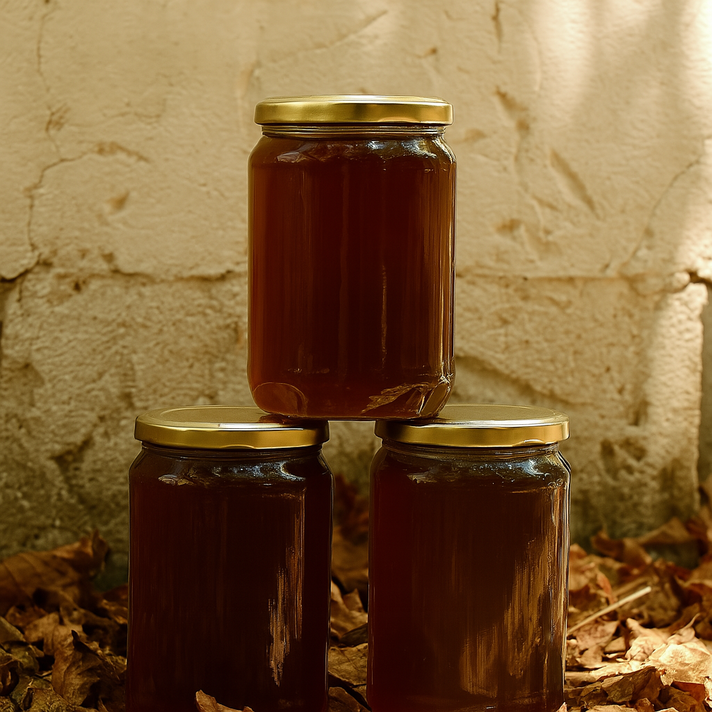 Three glass jars of honey placed on autumn leaves against a rustic wall, captured in warm natural light in Elesaar's Our Selection Page.